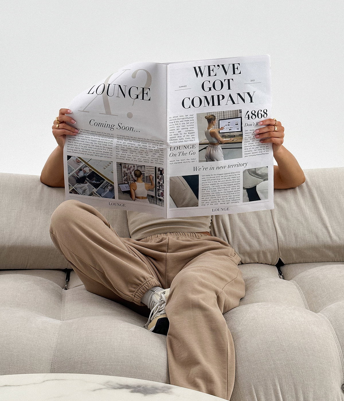 Lounge × Jess Hunt — Teaser frame: face hidden behind the mocked-up LOUNGE newspaper, 'WE'VE GOT COMPANY'