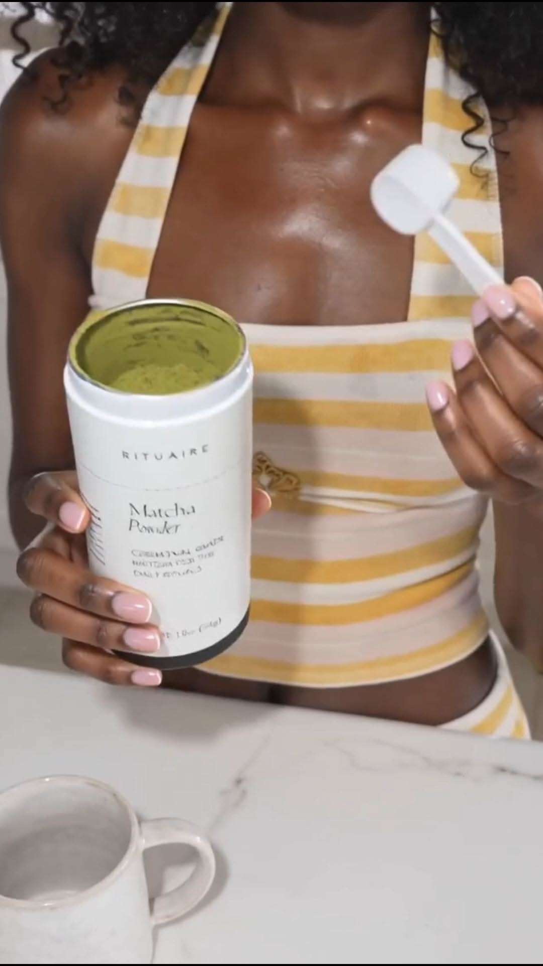 Holding the Rituaire matcha powder tub